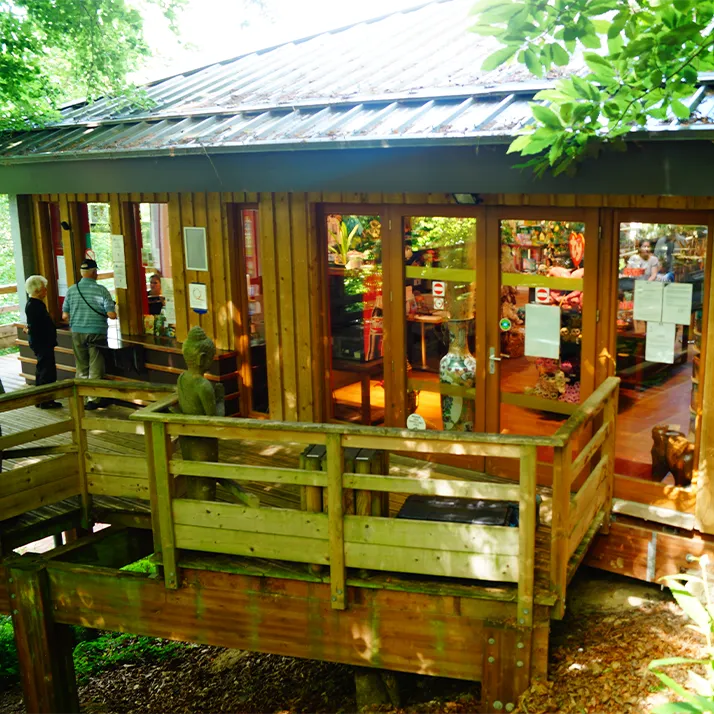 Wooden ZooParc shop building with terrace and railing, surrounded by trees