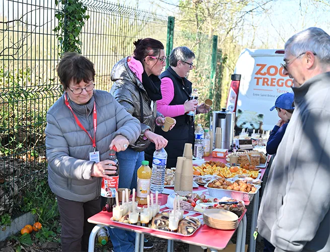 Bénévoles derrière une table de ravitaillement garnie de boissons et de gâteaux lors de Breizh Asia
