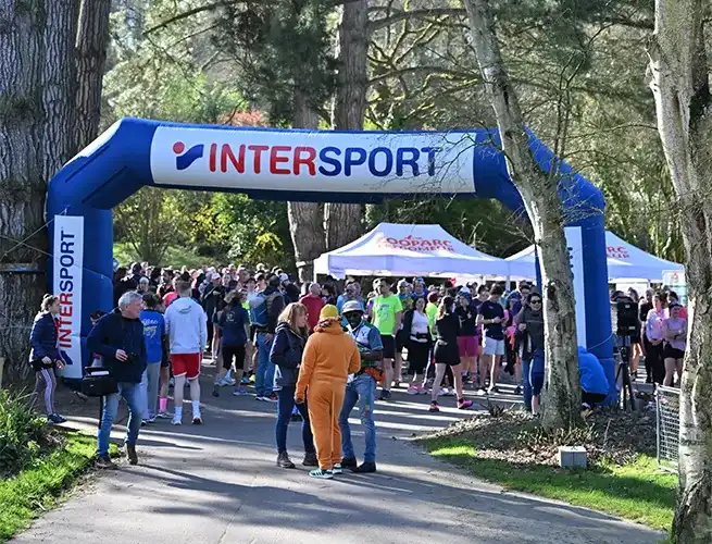 Foule de participants rassemblée sous l'arche Intersport au départ de la course Breizh Asia