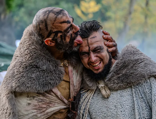 Deux hommes maquillés et vêtus de fourrures, complices et souriants, lors de l'événement d'Halloween