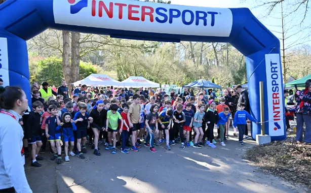 Start of a race under the Intersport inflatable arch with many young runners gathered together