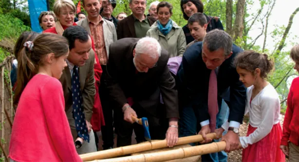 Elected officials and children planting bamboo together at the park's inauguration