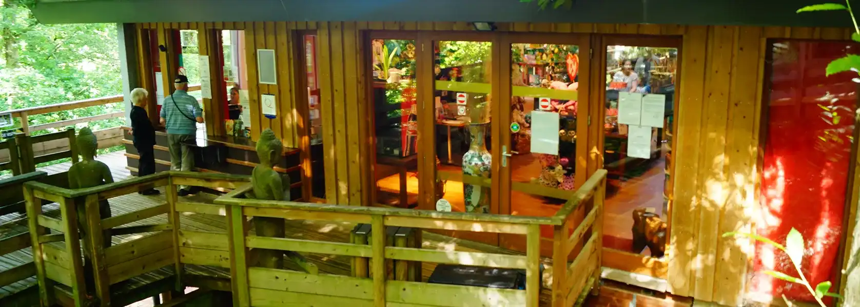 ZooParc wooden shop seen from a terrace, with lit display windows and visitors